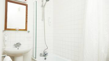 Un baño con lavamanos, espejo y ducha.