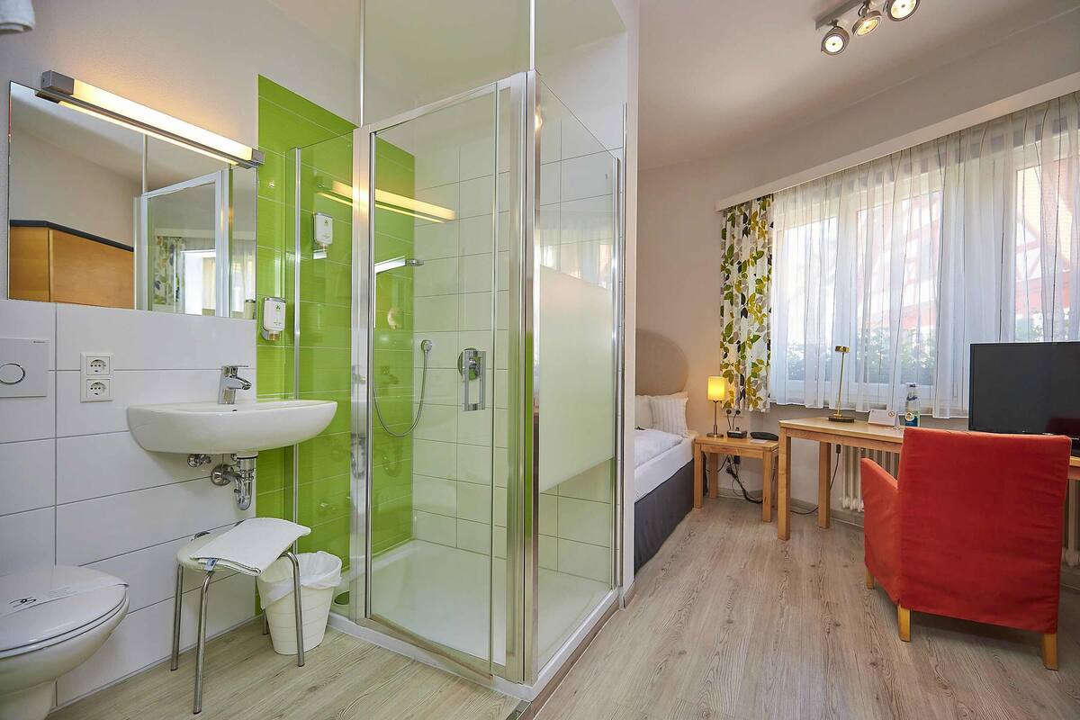 A modern bathroom with a glass-enclosed shower, a sink, and a toilet.