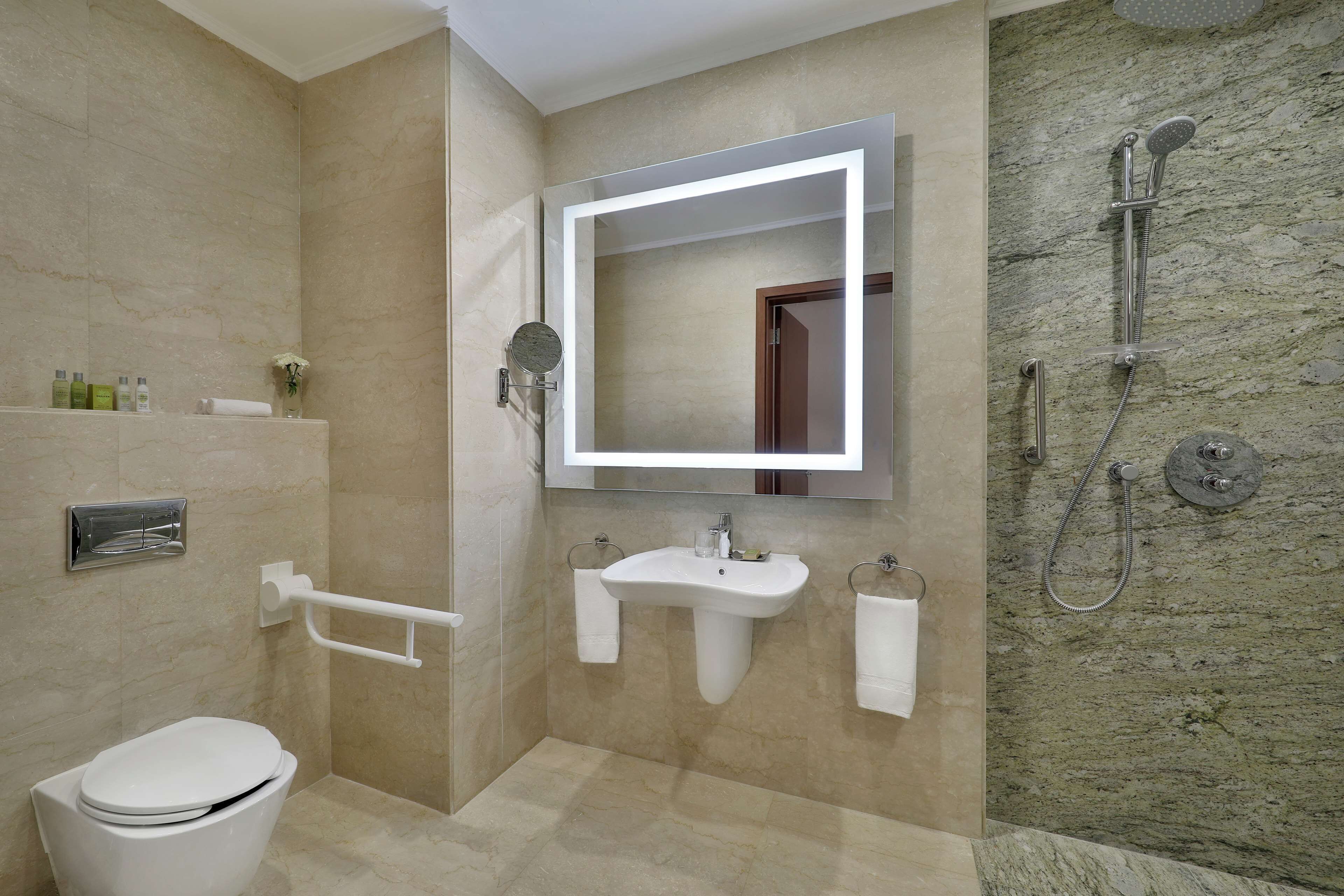 A modern bathroom with a toilet, sink, and shower.