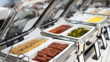 A buffet with various food items in glass containers, including what appears to be pastries and dips.