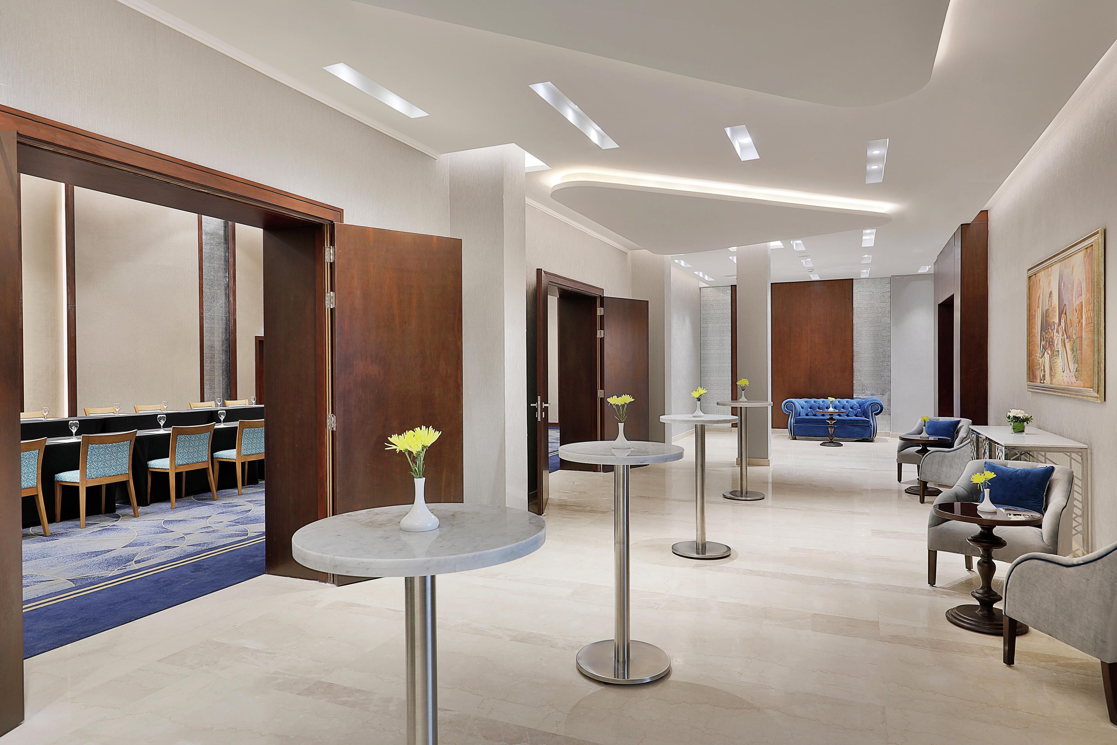 Un hall d’hôtel comprenant un comptoir d’accueil, un espace salon et un coin repas.