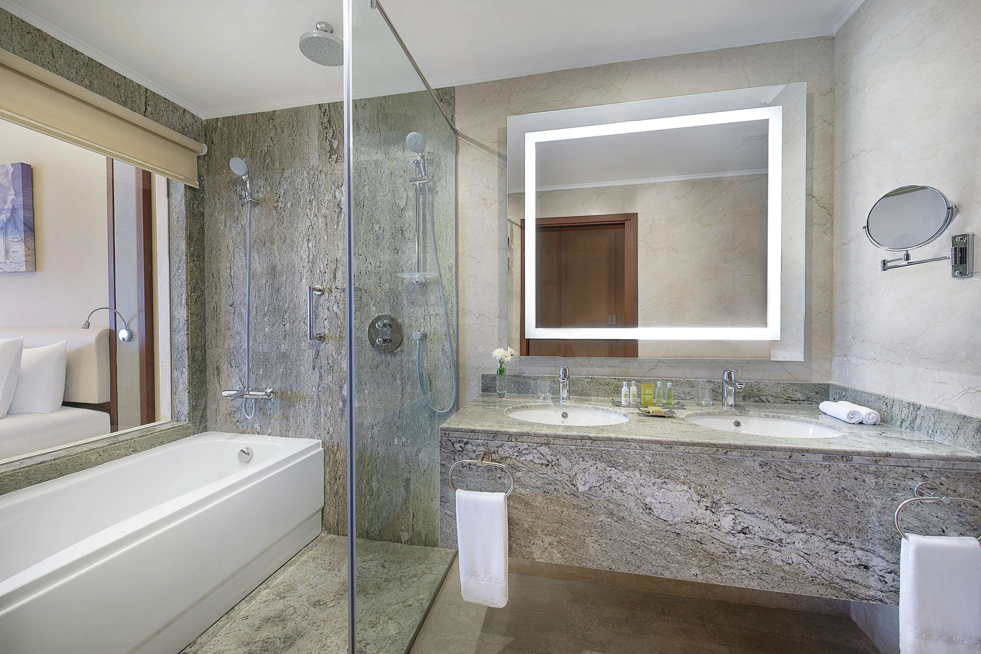 A modern bathroom with a glass-enclosed shower, a large mirror, and a double sink vanity.