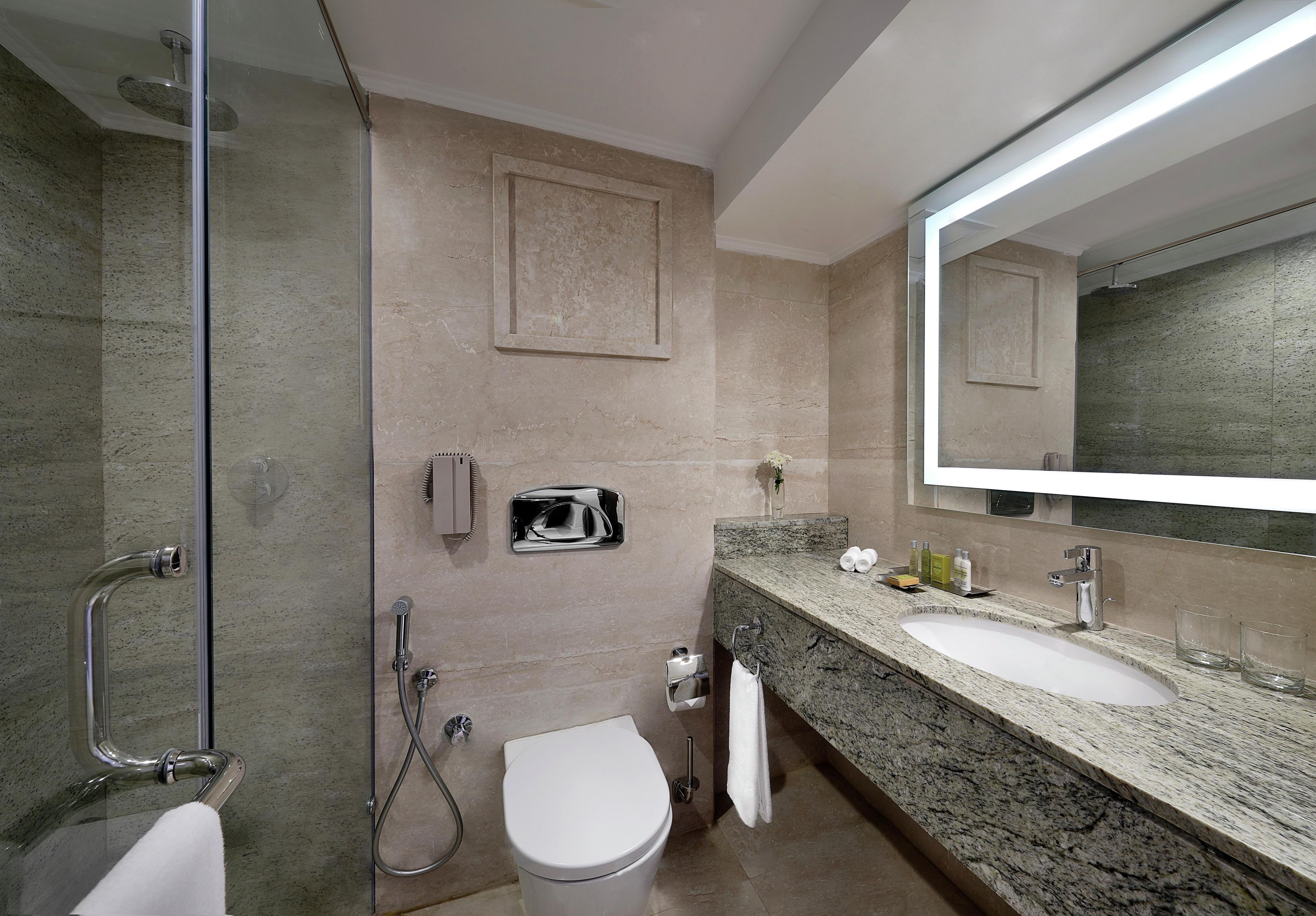 Une salle de bain moderne équipée d’une douche, de toilettes et d’un lavabo.