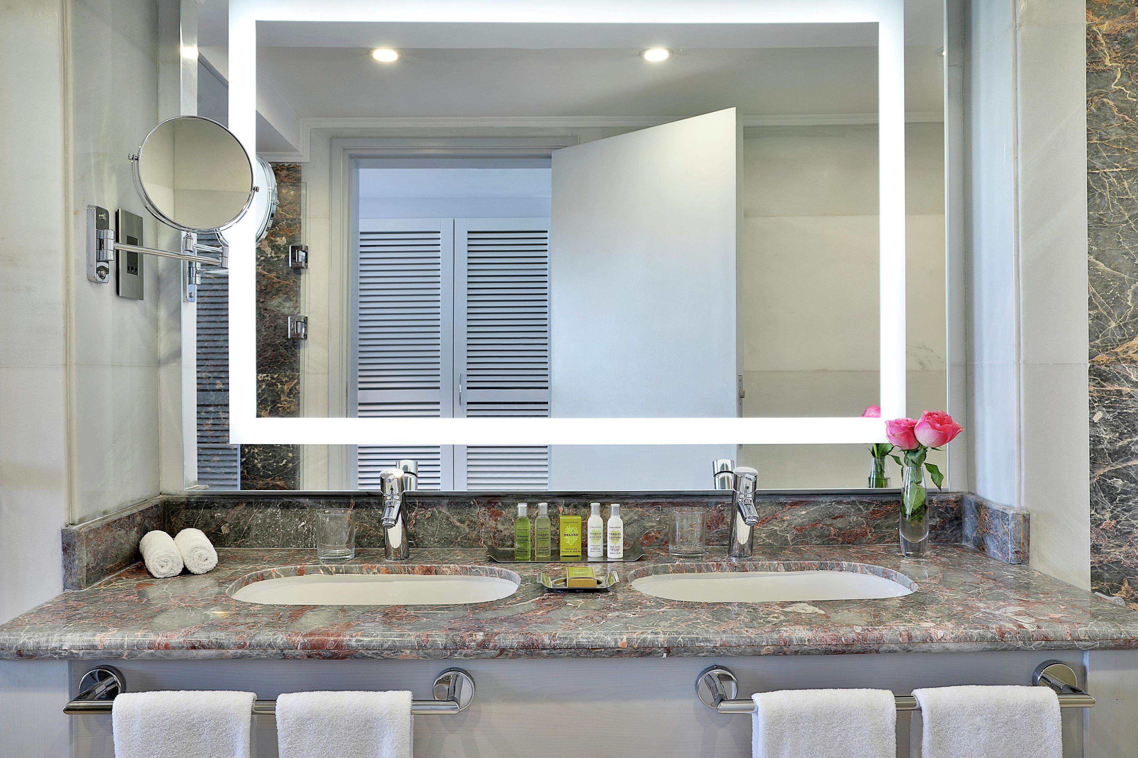 A bathroom with two sinks, a large mirror, and a marble countertop.