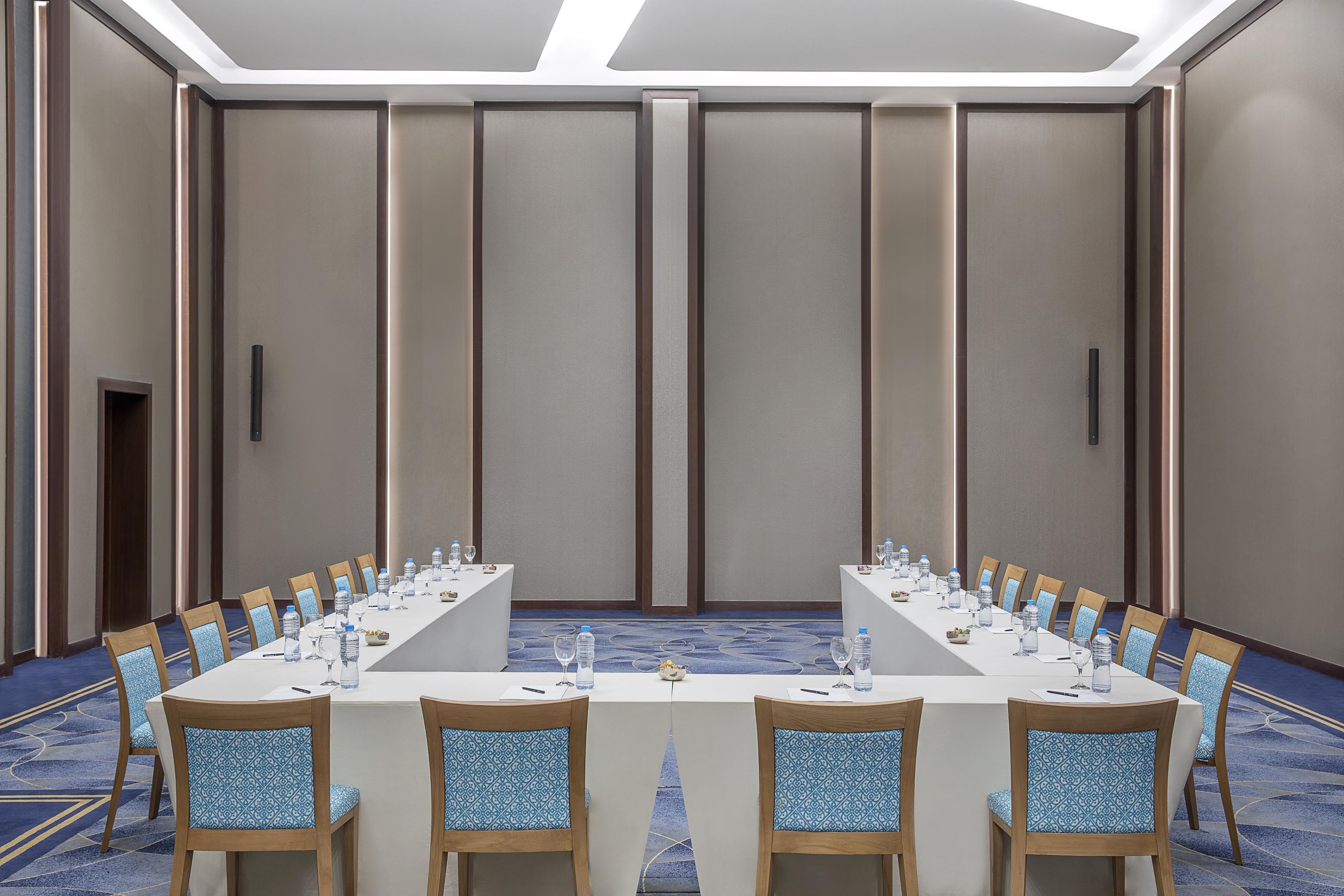 A conference room with a long table, chairs, and water bottles.