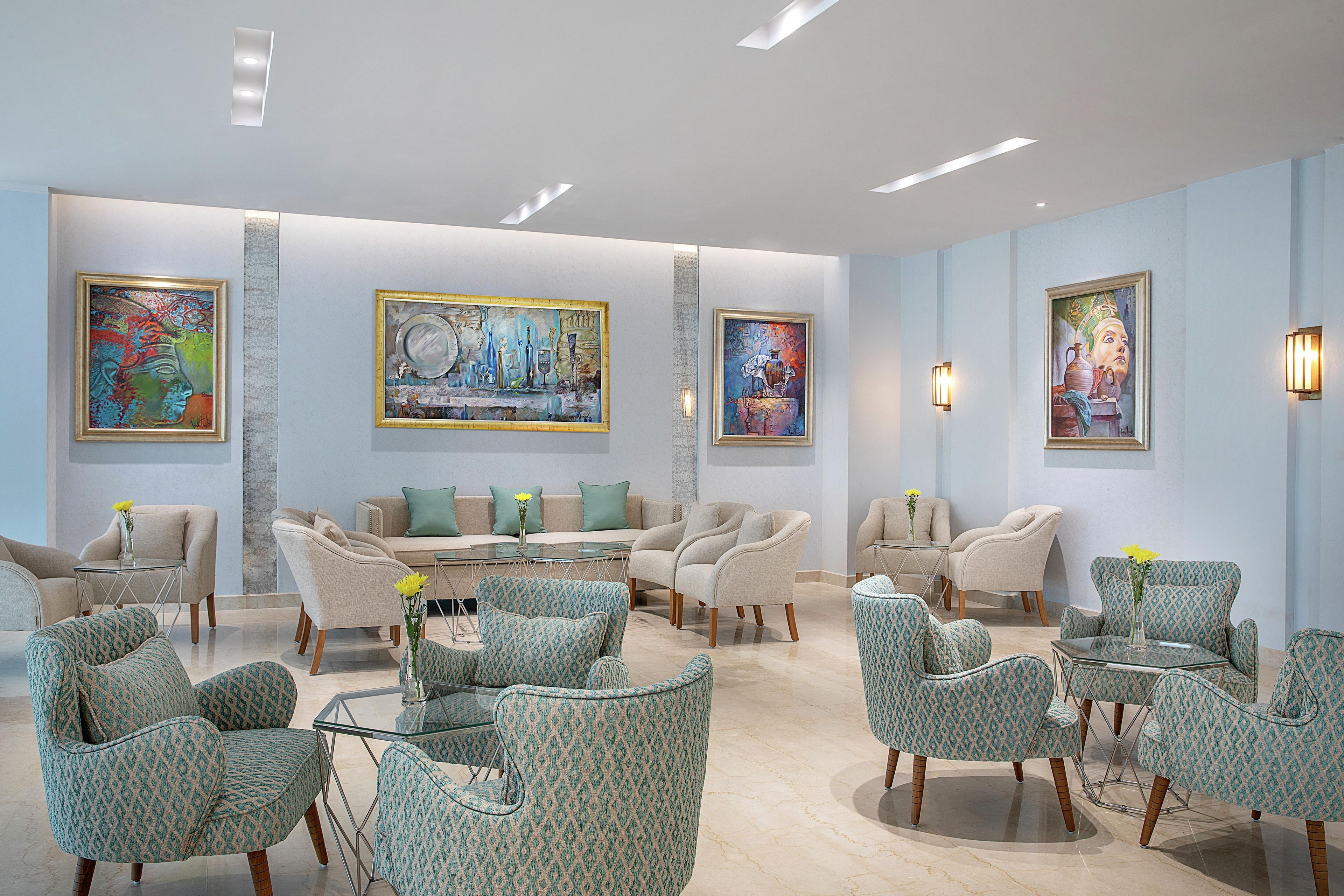 Een hotel lobby met een zithoek, kunstwerken aan de muren en een modern design.