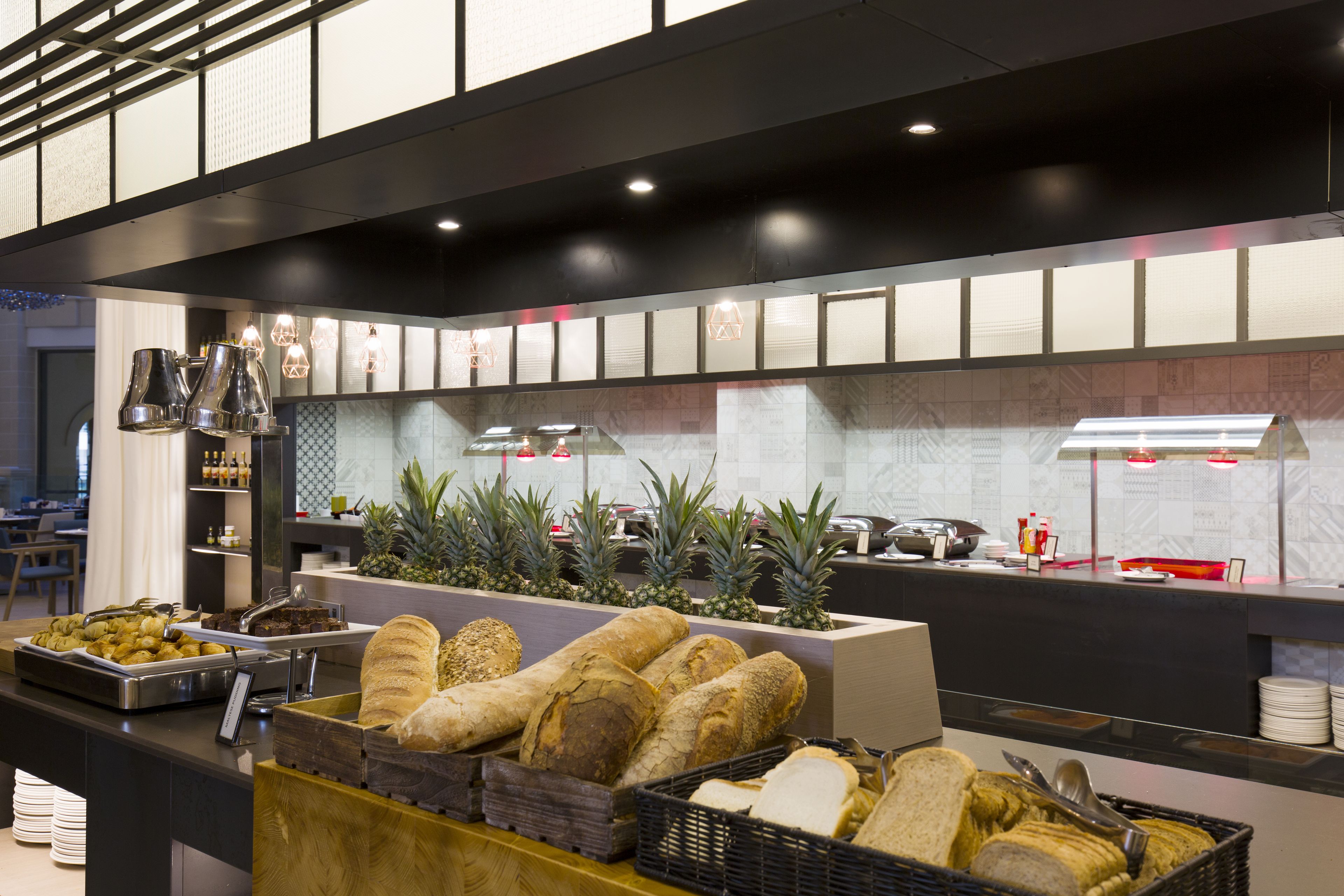A buffet area with various food items, including bread and fruits, and a counter with kitchen appliances.