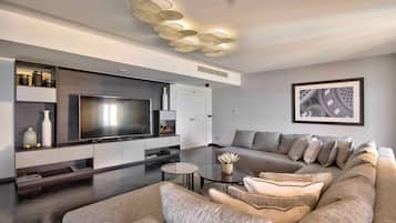Una sala de estar moderna con un televisor de pantalla plana grande, un sofá modular y una mesa de centro.