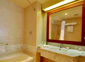 A bathroom with a bathtub, a shower, a sink with toiletries, and a large mirror. - Safir Sharm Waterfalls Resort (Sharm El Sheikh)