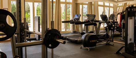 A gym with weightlifting equipment, treadmills, and exercise machines.