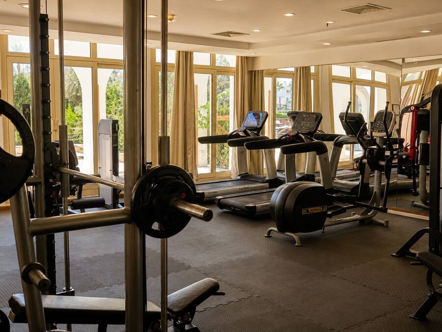 A gym with weightlifting equipment, treadmills, and exercise machines.