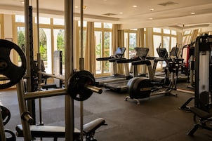 A gym with weightlifting equipment, treadmills, and exercise machines.