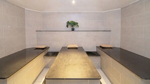 A spa room with three massage tables, a shelf with a plant, and tiled walls. - Safir Sharm Waterfalls Resort (Sharm El Sheikh)