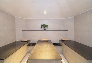 A spa room with three massage tables, a shelf with a plant, and tiled walls. - Safir Sharm Waterfalls Resort (Sharm El Sheikh)