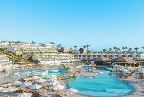 A resort with multiple swimming pools, sun loungers, and umbrellas.