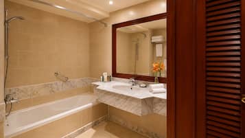A bathroom with a bathtub, a shower, and a vanity with a mirror.