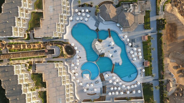 An aerial view of a resort with multiple swimming pools, sun loungers, and a central plaza. - Safir Sharm Waterfalls Resort (Sharm El Sheikh)