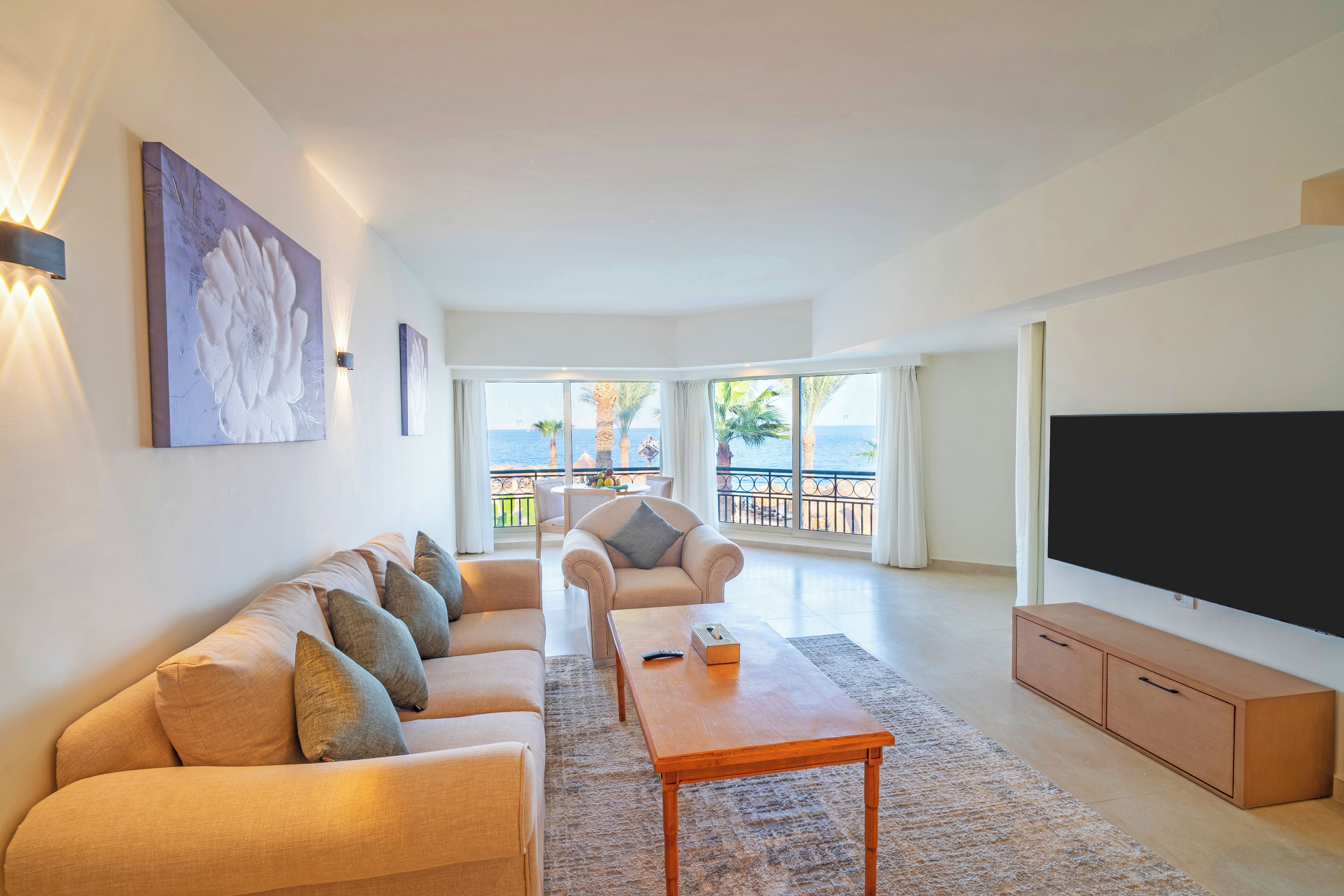 Una sala de estar amplia con un sofá, una mesa de centro y un televisor de pantalla plana.