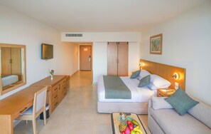 A hotel room with a bed, a sofa, a desk, and a TV. - Safir Sharm Waterfalls Resort (Sharm El Sheikh)