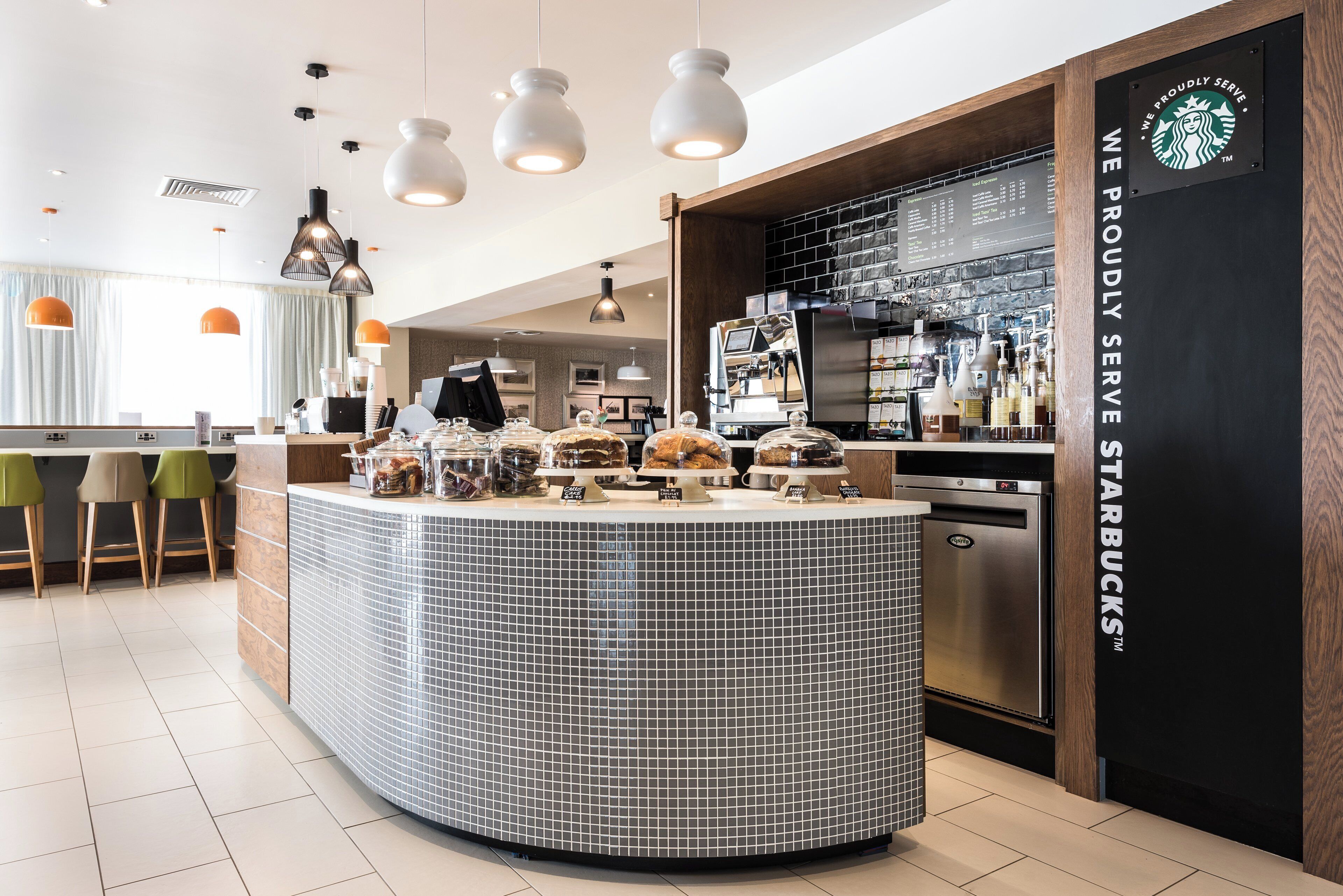 En modern inredning för ett kafé, med en central disk, sittområde och en Starbucks-skylt.