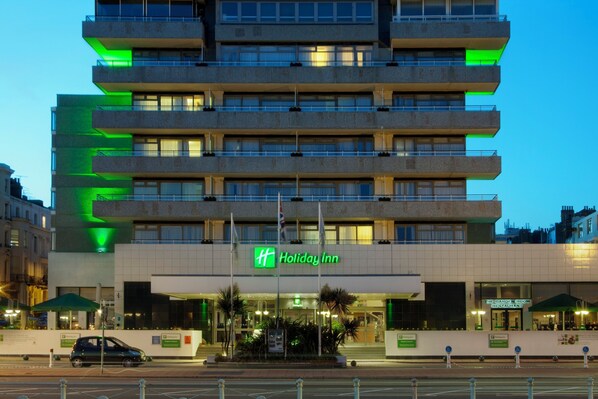 Experience the sleek, modern design of this Holiday Inn hotel, featuring a flat facade and balconies on each floor.