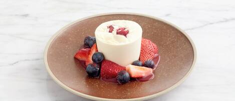 Ein Dessert mit Erdbeeren und Blaubeeren auf einem Teller.