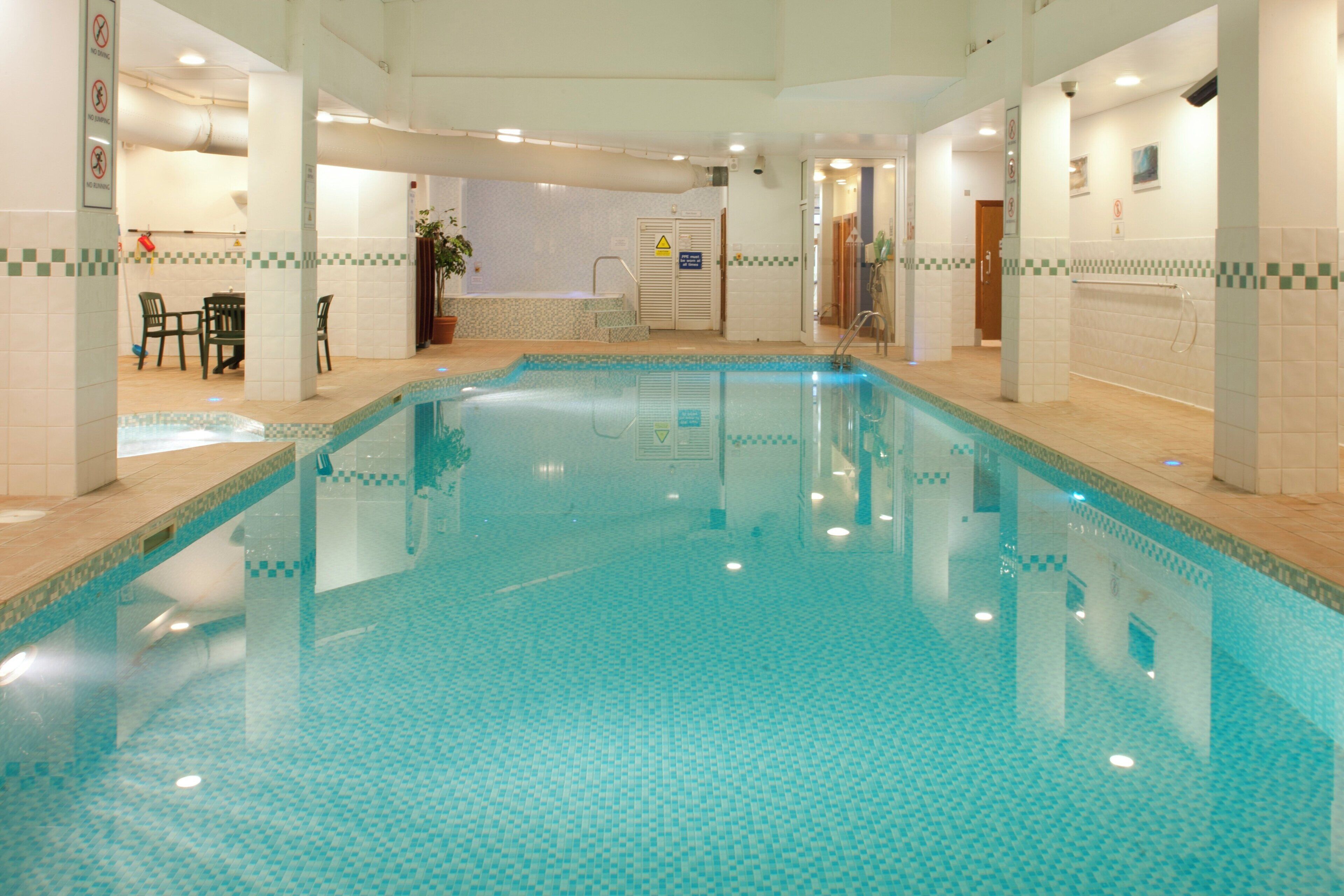 Una piscina interior con paredes y suelo de baldosas.