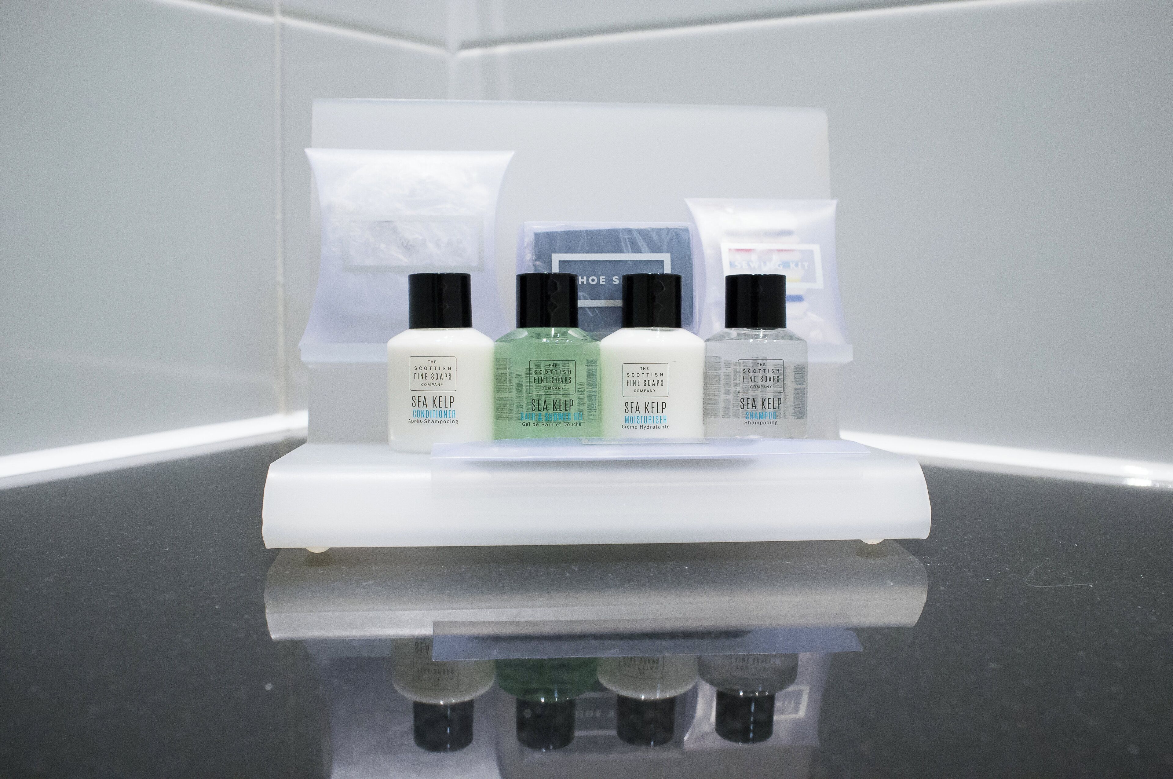 A display of The Scottish Fine Soaps products on a reflective surface.