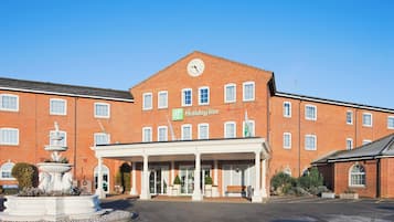 Un edificio de ladrillo con un reloj y un letrero que dice 'Holiday Inn'.