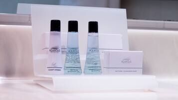 A display of Aqueous Collection products including a shower gel, shampoo, and a natural cleansing bar.