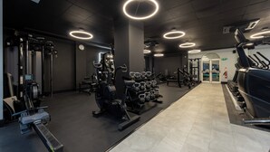 A gym with exercise equipment, a weight rack, and a treadmill. - Holiday Inn Corby Kettering Hotel & Spa (Corby)