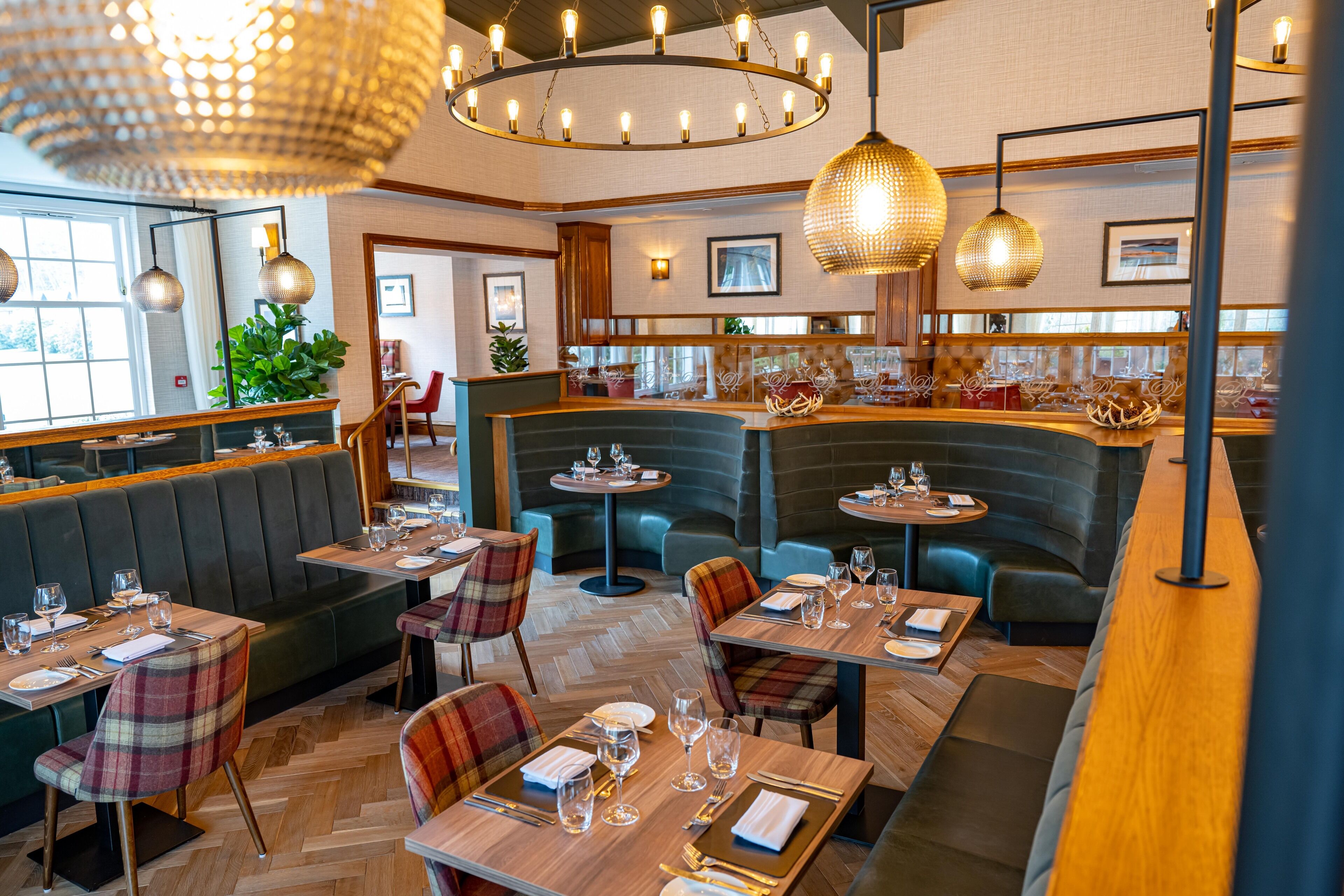 En restaurant med båse, runde borde og et barområde.