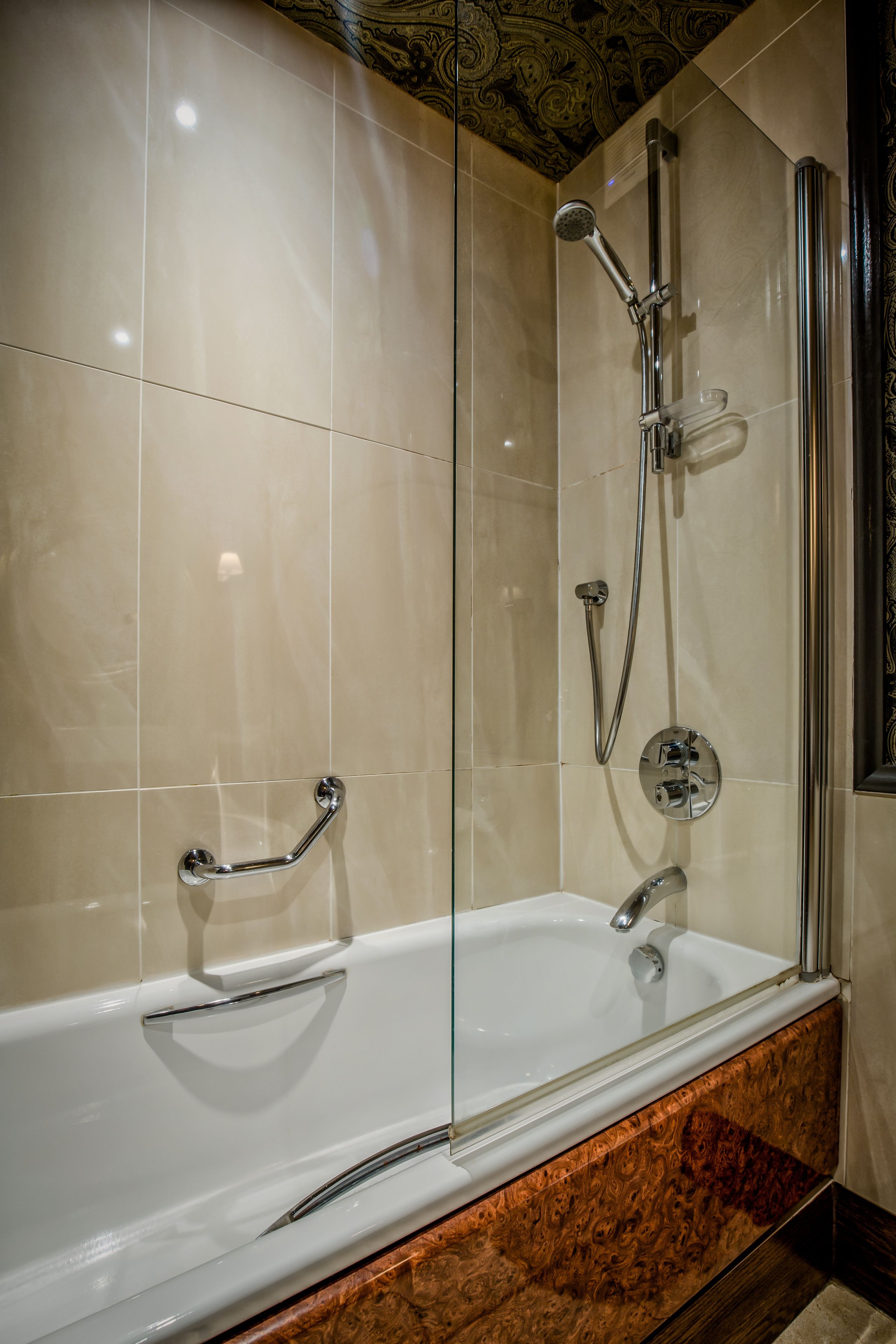 Une salle de bain moderne avec une douche à parois de verre, une baignoire blanche et un comptoir en marbre.