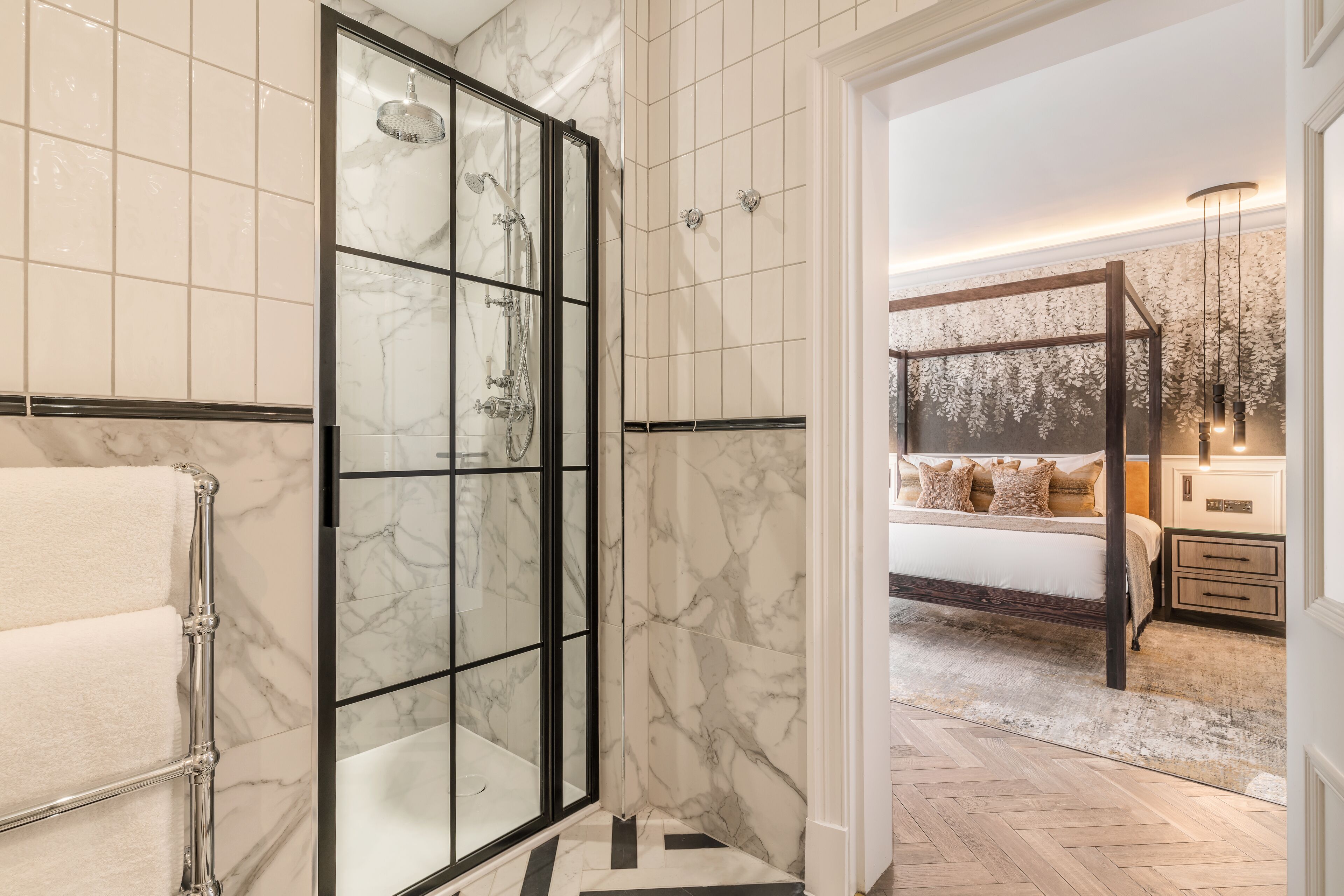 A bathroom with a glass shower enclosure and a separate toilet area.
