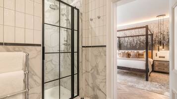 A bathroom with a glass shower enclosure and a separate toilet area.