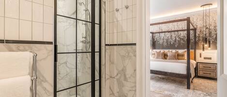 A bathroom with a glass shower enclosure and a separate toilet area.