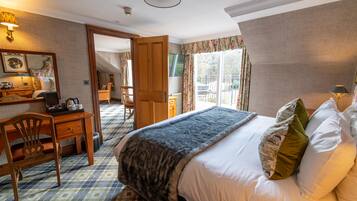 A hotel room with a bed, a desk, a chair, and a view of the outdoors.