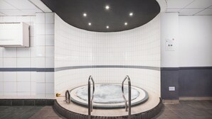 A modern indoor pool area with a circular hot tub, tiled walls, and a ceiling with recessed lighting. - Holiday Inn Glasgow East Kilbride by IHG (Glasgow)