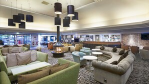 A modern lounge area with sofas, armchairs, and a central fire feature. - ORIDA Hotels Newbury (Newbury)