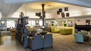 A spacious lobby with multiple seating areas, a reception desk, and a patterned carpet. - ORIDA Hotels Newbury (Newbury)