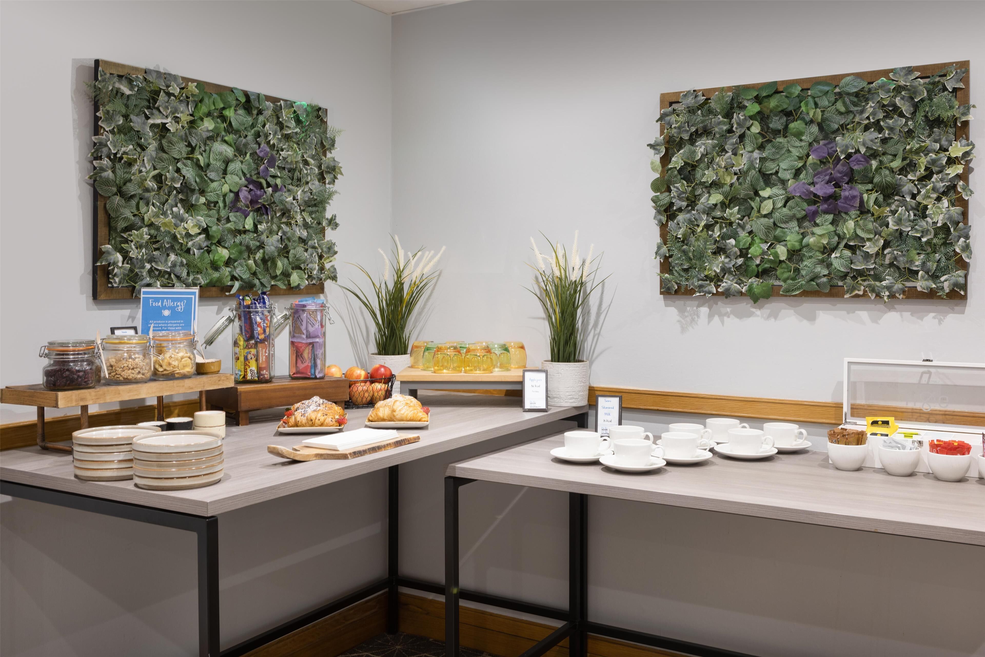 A breakfast bar with a variety of food items and a sign indicating a food allergy policy.
