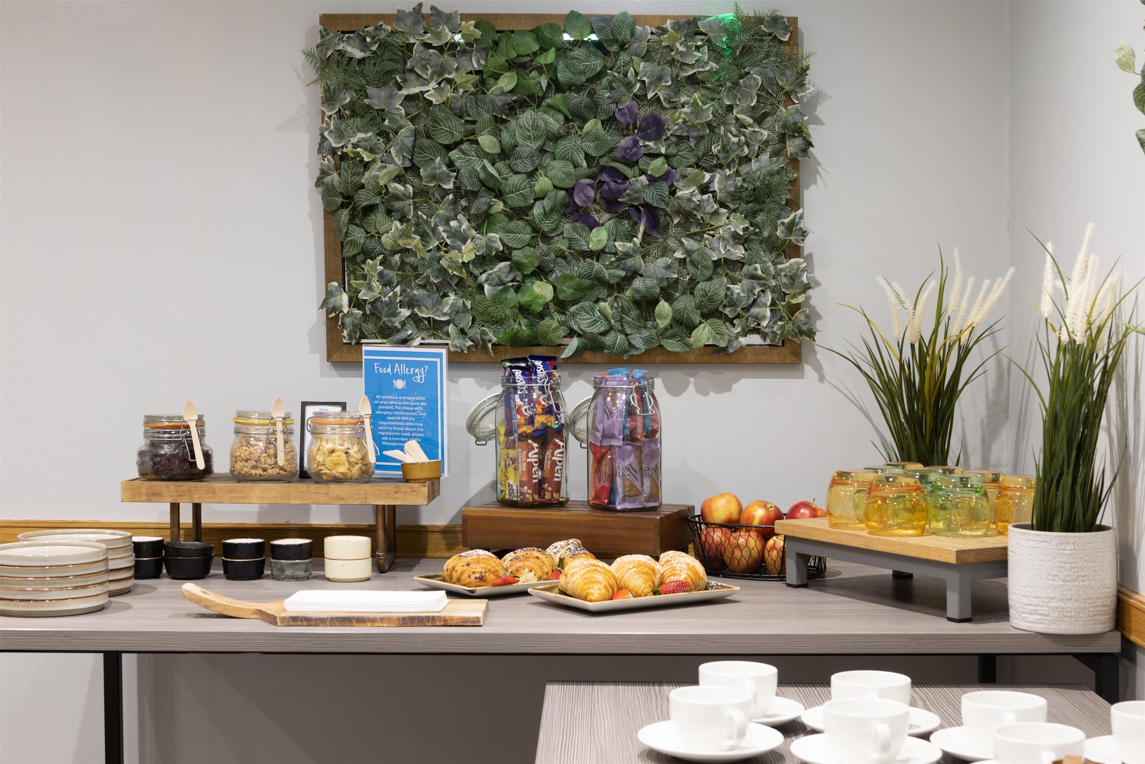 Un buffet de petit-déjeuner proposant une variété d’aliments, notamment des viennoiseries, des fruits et des boissons.