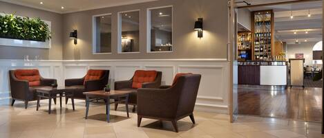 A lobby with seating, a bar area, and a reception desk.