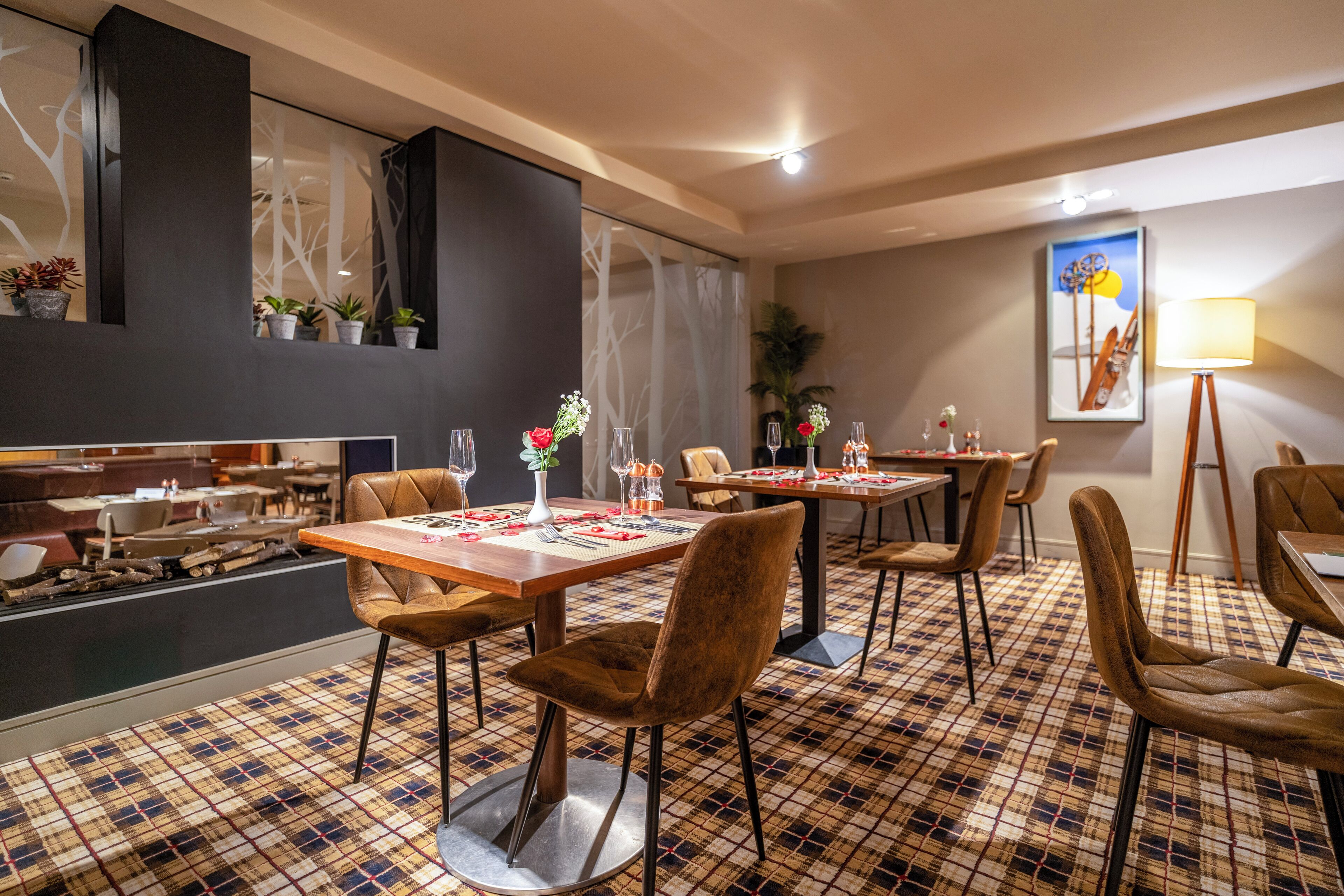 Ein Restaurant mit Schachbrettmuster-Boden, Holztischen und braunen Polsterstühlen.