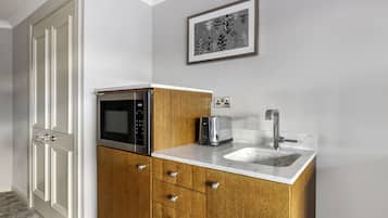 Una cocina compacta con microondas, tostadora y pileta.