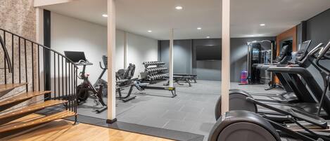 A gym with treadmills, stationary bikes, and weight machines.