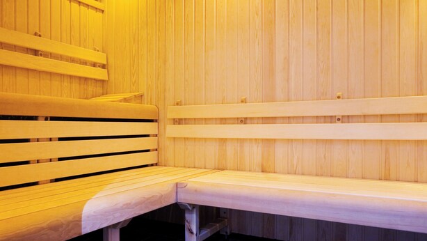 Eine Holzsauna mit Bänken und einer Sitzbank.