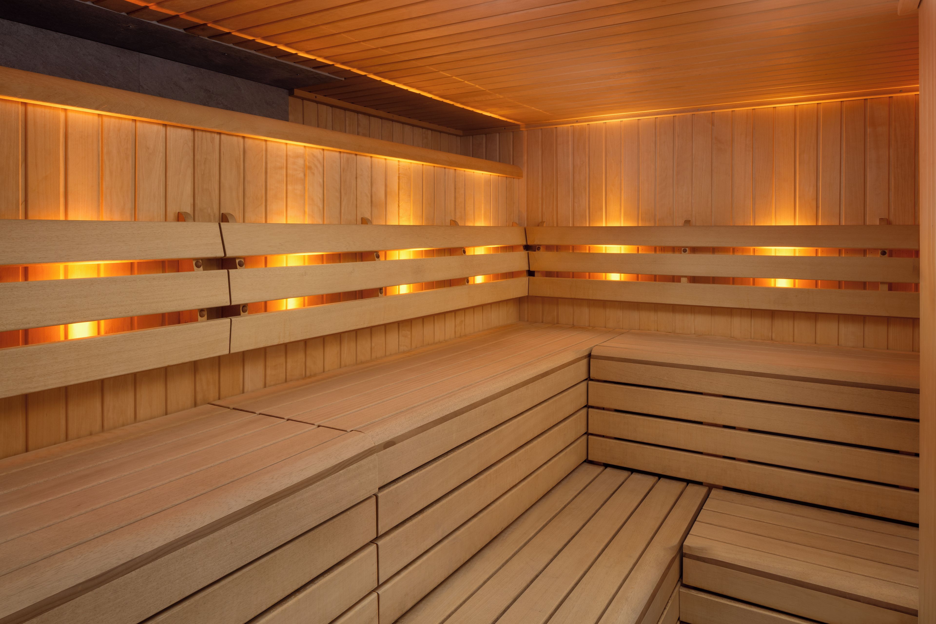Un sauna avec des bancs en bois et des bancs dotés de dossiers.