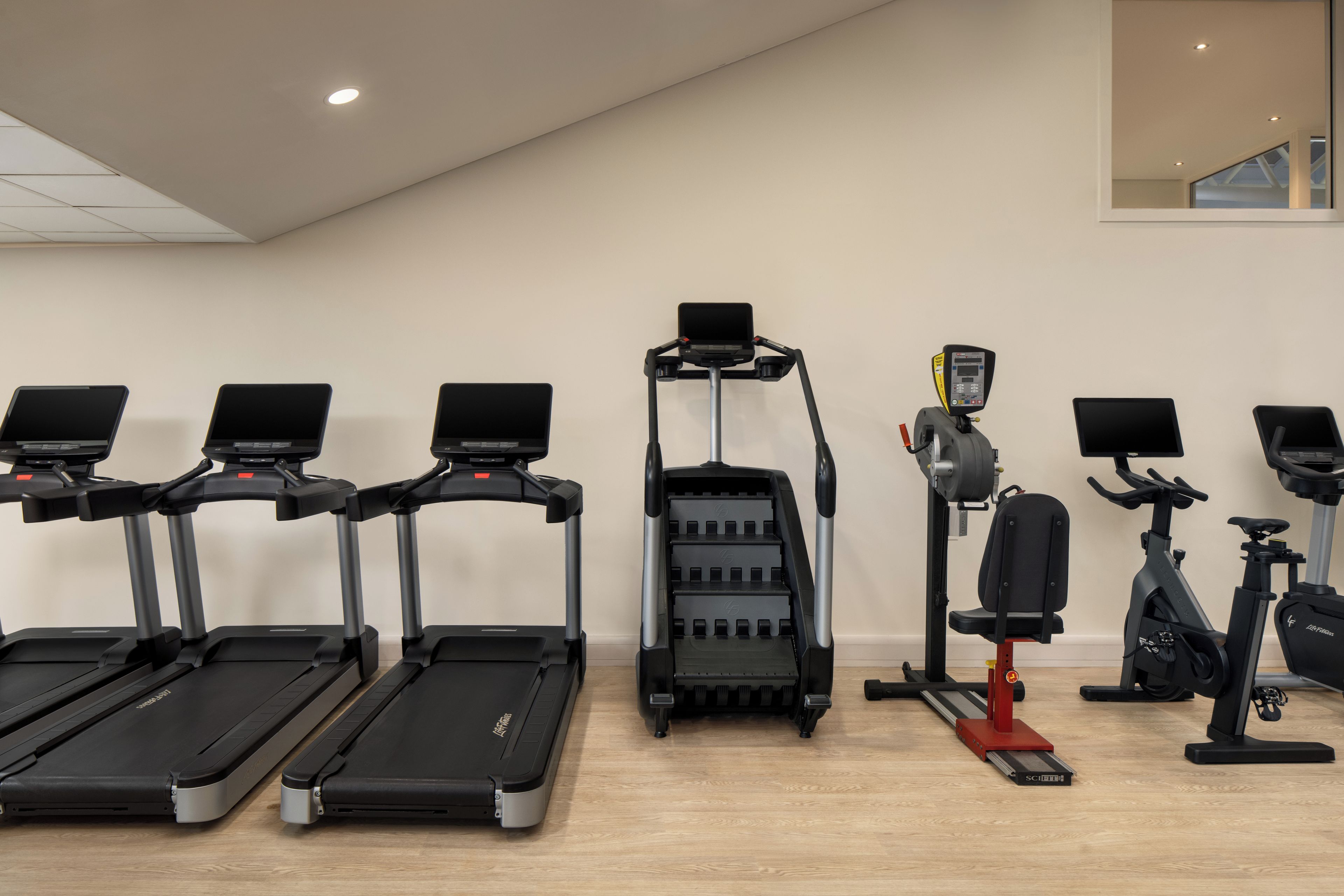 A gym with treadmills, an elliptical, and a stationary bike.