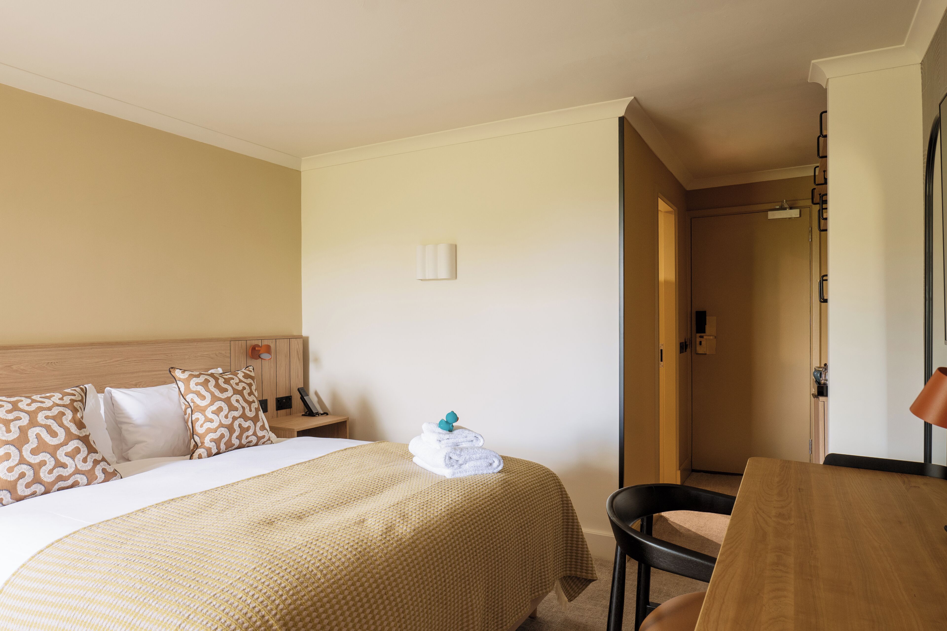 Una habitación de hotel con una cama, un escritorio y una silla.